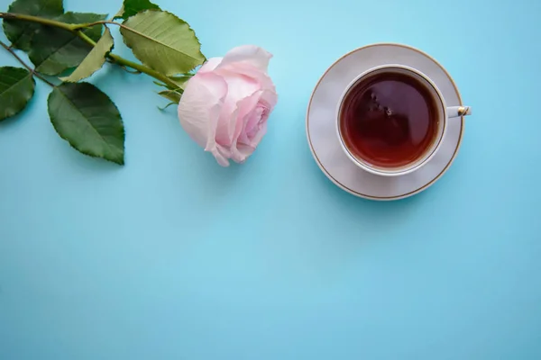 Романтическая картина с розой и чашкой чая — стоковое фото