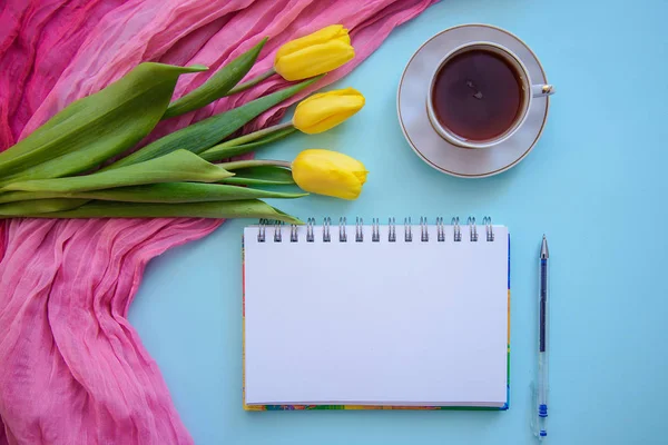 Красивая романтическая фотография с блокнотом, чаем и тюльпанами на синем фоне — стоковое фото