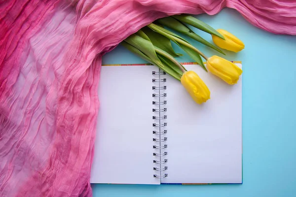 Krásný Romantický obrázek s Poznámkový blok, čaj a tulipány na modrém pozadí — Stock fotografie