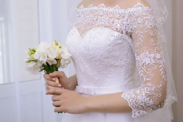 Невеста держит свадебный букет близко — стоковое фото