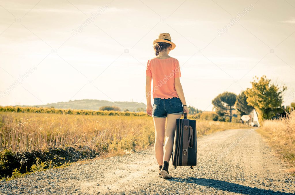 Woman walking with valise on field