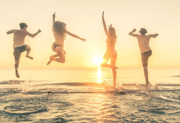 Gruppo di amici jamping sul mare — Foto Stock