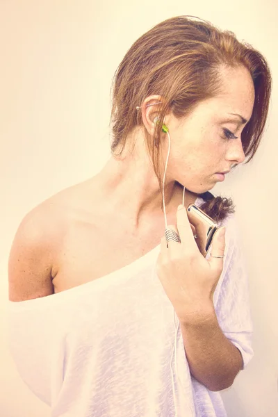 Руда дівчина слухає музику з навушників — стокове фото