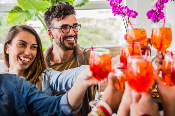 Grupa młodych przyjaciół wznoszących toast koktajlami bawiącymi się na imprezie weekendowej — Zdjęcie stockowe