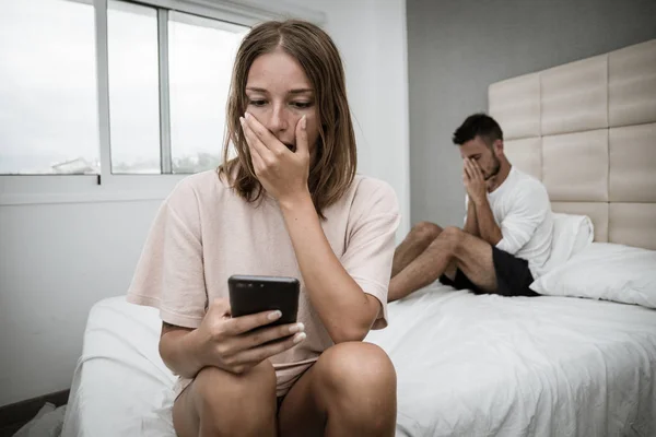 Traurige Frau erfährt von Verrat ihres Freundes durch Bespitzelung seines Telefons — Stockfoto