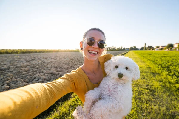 Молодая и красивая женщина делает селфи со своей собакой в парке — стоковое фото