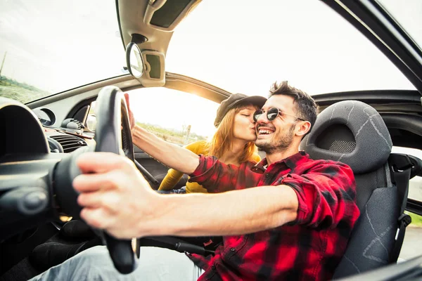 幸せなカップルは、道路上の日没でコンバーチブル車を運転 — ストック写真