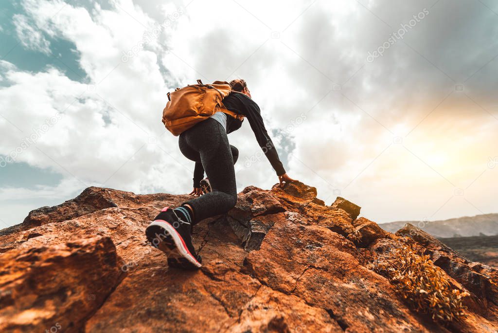 Success woman hiker hiking on sunrise mountain peak 