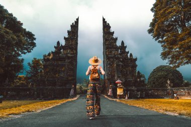 Sırt çantalı turist kadın Endonezya, Bali 'deki Hindu tapınağında yürüyor.