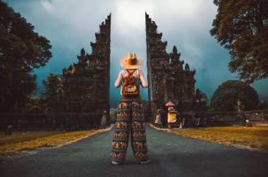 Sırt çantalı turist kadın Endonezya, Bali 'deki Hindu tapınağında yürüyor.