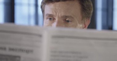 Ağır çekim bir gazete okuyor başarılı emin işadamı portresi. Yakın çekim iş bilgi kavramı. İşadamı serisi. 4k Uhd 4096 x 2160.