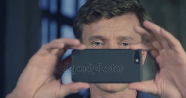 Ağır çekim Smartphone stüdyoda çekim kamera ile çekici bir adam portresi. İşadamı serisi. 4k 4096 x 2160.