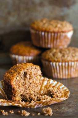 Muffins içinde belgili tanımlık geçmiş ve bir kepekli kek kırıntıları yakından.