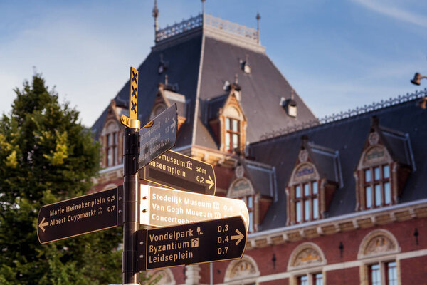 Вид на здания, деревья и уличные указатели
