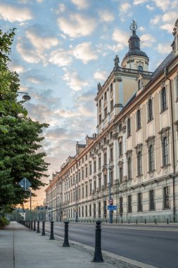Yüksek binalar, yeşil ağaçlar ve bulutlu gökyüzü uykulu kasaba gündoğumu görünümünde