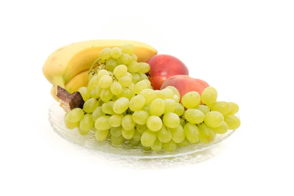 Banany, winogrona, brzoskwinie, nektarynki, na talerzu — Zdjęcie stockowe