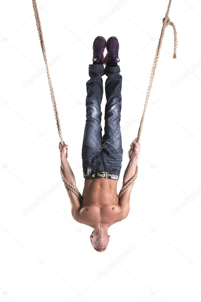 A man hangs on the ropes upside down isolated on white background