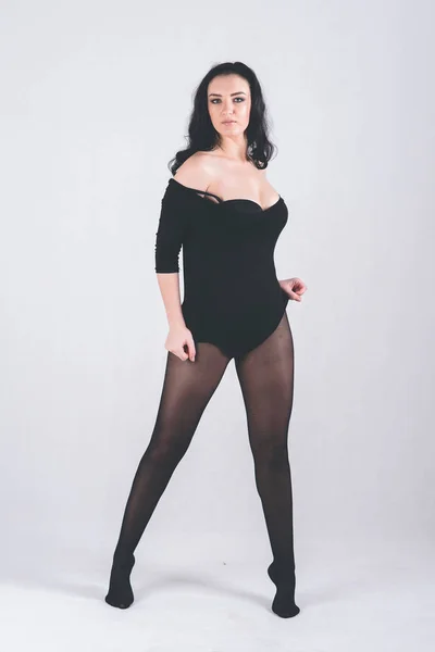 Chica completa en negro bodysuit stands, sobre fondo claro —  Fotos de Stock