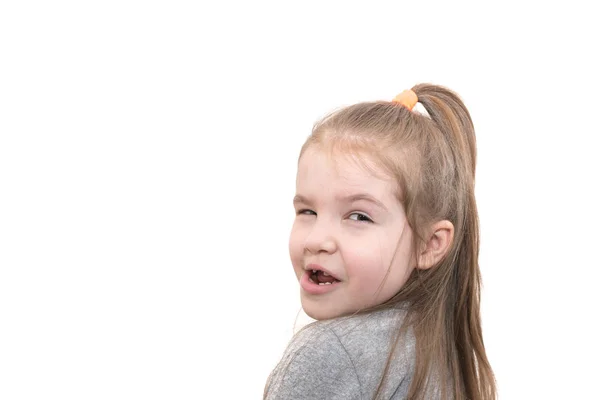 Schönes kleines Mädchen, überrascht und entrüstet, über ihre Schulter schauend, isoliert auf weißem Hintergrund — Stockfoto