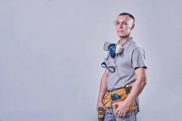Master Builder-finalizador en ropa de trabajo, con un destornillador de taladro en la mano — Foto de Stock