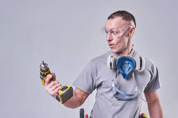 Master Builder-finalizador em suas roupas de trabalho, surpreendeu a broca — Fotografia de Stock