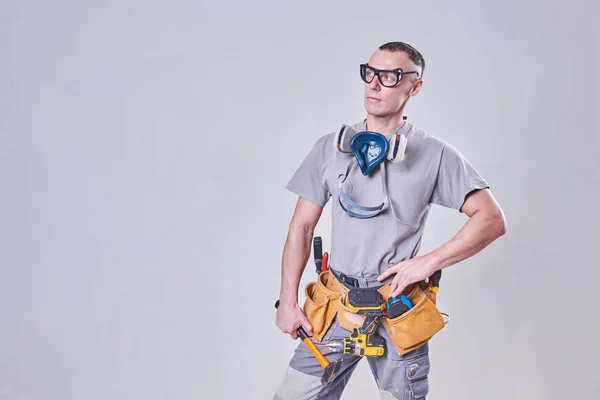 Mestre Construtor-finalizador em suas roupas de trabalho, com um martelo em sua mão — Fotografia de Stock