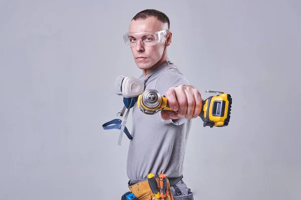 Master Builder-finalizador en ropa de trabajo, con un destornillador de taladro en la mano —  Fotos de Stock
