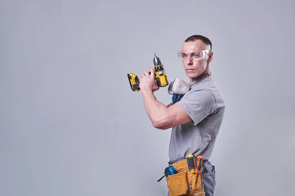 Master Builder-finalizador en ropa de trabajo, con un destornillador de taladro en la mano — Foto de Stock