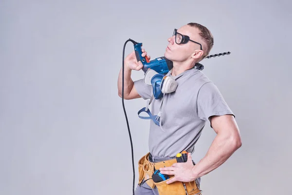 Master Builder-finalizador em roupas de trabalho, com um perfurador no ombro — Fotografia de Stock