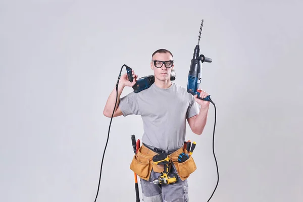 Master-Builder-finalizador en su ropa de trabajo, con dos martillos en sus manos —  Fotos de Stock