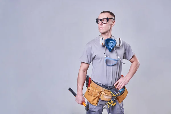 Master Builder-finisher en su ropa de trabajo, con un martillo en la mano —  Fotos de Stock