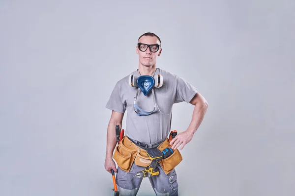 Master Builder-finisher en su ropa de trabajo, con un martillo en la mano —  Fotos de Stock