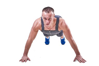 Güzel erkek spor giyim beyaz bir arka plan üzerinde izole şınav yapar