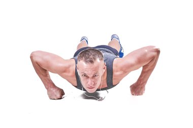 Güzel erkek spor giyim beyaz bir arka plan üzerinde izole şınav yapar