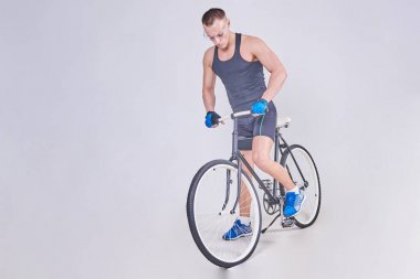 Bir bisiklet üzerinde bir yakışıklı spor adam oturuyor