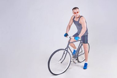 Bir bisiklet üzerinde bir yakışıklı spor adam oturuyor