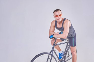 Bir bisiklet üzerinde bir yakışıklı spor adam oturuyor