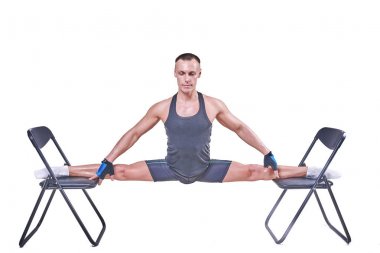 Yakışıklı bir erkek spor giyim beyaz bir arka plan üzerinde izole sandalyelere enine bir sicim, gerçekleştirir