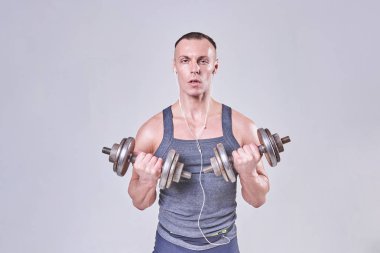 Sportif yakışıklı elinde dumbbells ile egzersiz yaparak