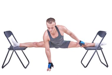 Yakışıklı bir erkek spor giyim beyaz bir arka plan üzerinde izole sandalyelere enine bir sicim, gerçekleştirir