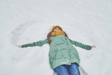 Güzel genç kız karda yalan. bir kar melek yapma
