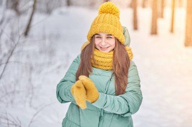 Kış orman arka plan üzerinde örgü şapkalı güzel genç kız