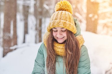 Kış orman arka plan üzerinde örgü şapkalı güzel genç kız