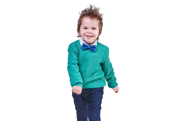 잘생긴 소년, 블루 나비 넥타이 녹색 스웨터를 입고, 걷고, 웃 고, 흰색 배경에 고립 — 스톡 사진