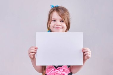 Beyaz kağıdın elinde tutan güzel küçük kız