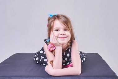 Güzel bir kız yatıyor, elleri ve gülümseyerek başını tutan