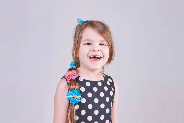 Una hermosa niña sonríe una sonrisa sin dientes — Foto de Stock