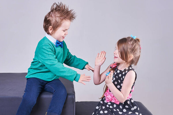 Beautiful little boy and girl clap their hands and smile