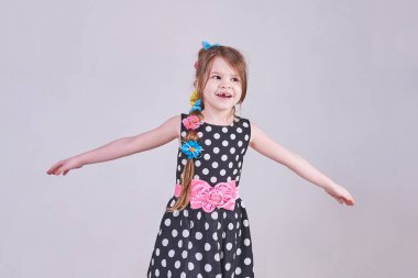 Küçük bir güzel kız gülümsüyor, onu yaymak taraf için eller