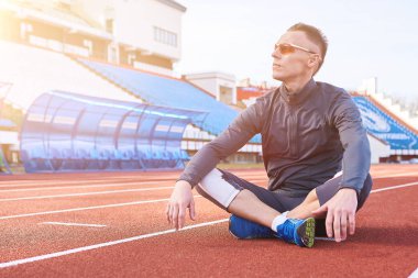 Lotus poz stadyum treadmill bir yakışıklı spor adam oturuyor
